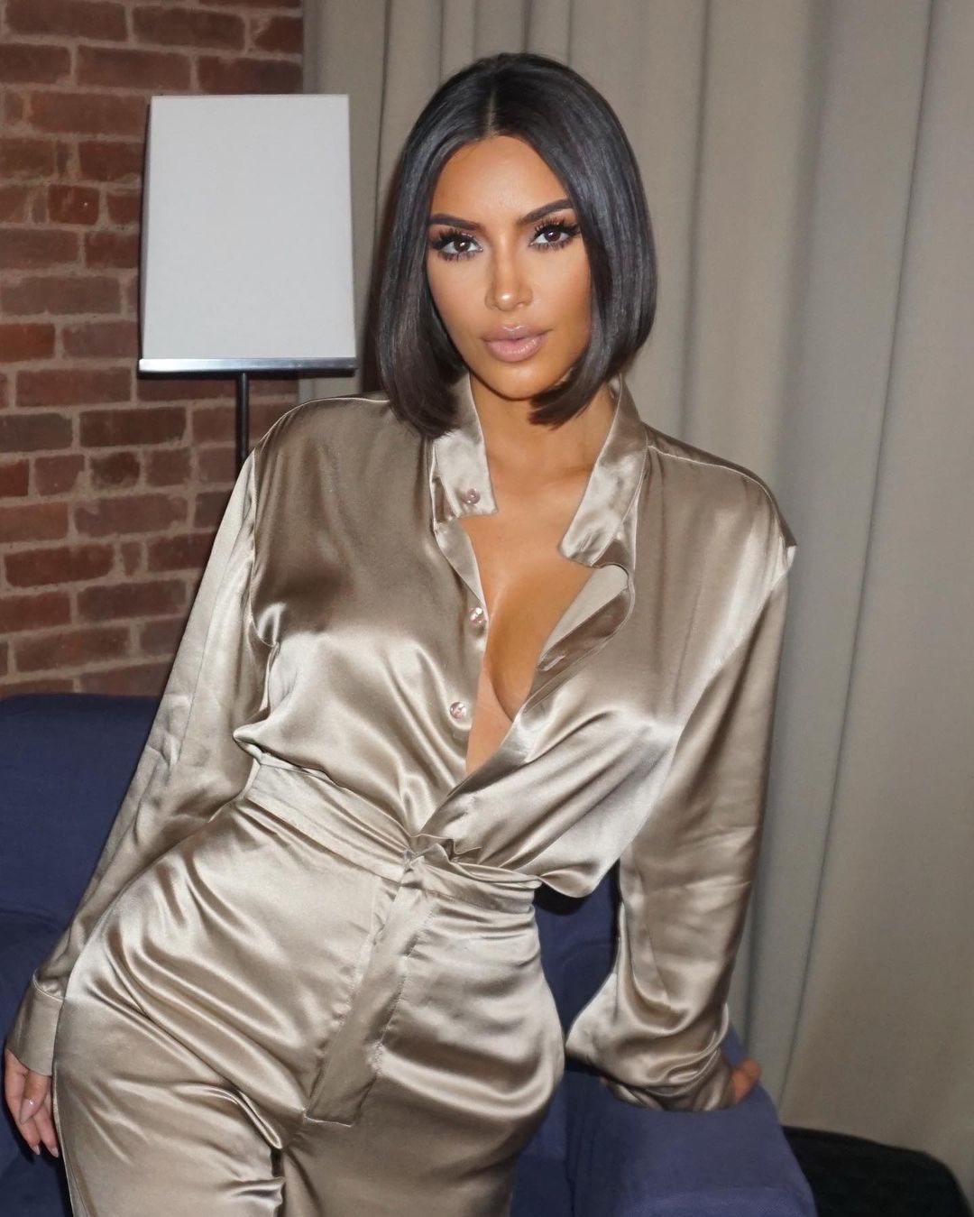 A photo of Kim Kardashian sporting a brown two-piece outfit with a bulb hairstyle.