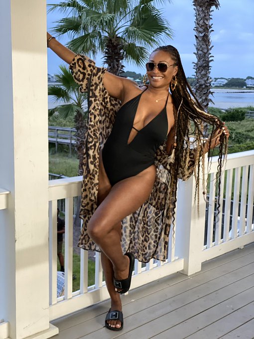 Cynthia Bailey wears a black swimsuit with a leopard cover-up.