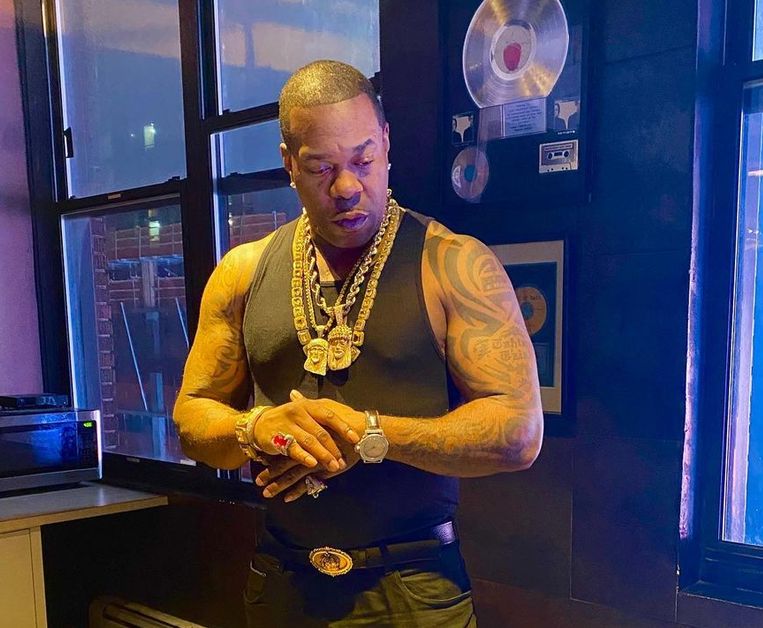 Busta Rhymes wears a tight-fitting black A-shirt as he shows off his tattooed arms.
