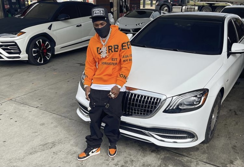 DaBaby in front of one of his cars.