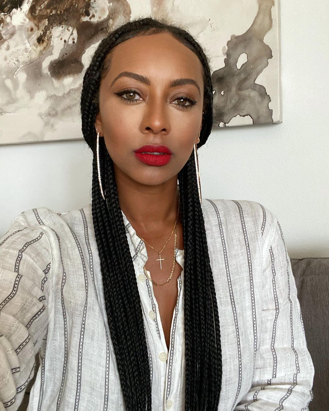 Keri Hilson looks dazzling in this selfie, showing her in a white striped outfit and golden cross necklace.