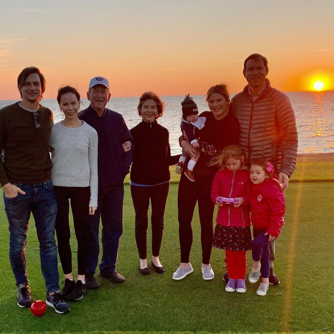 An incredible photo of some of the Bush family on a plain field near the beach at sunset and they all look amazing in casual outfits.