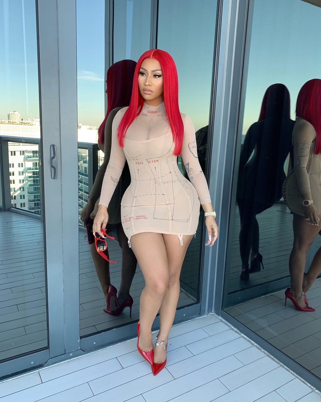 Nicki Minaj looks breathtakingly beautiful in this photo showing her in a brown skin-hug dress and red pumps.