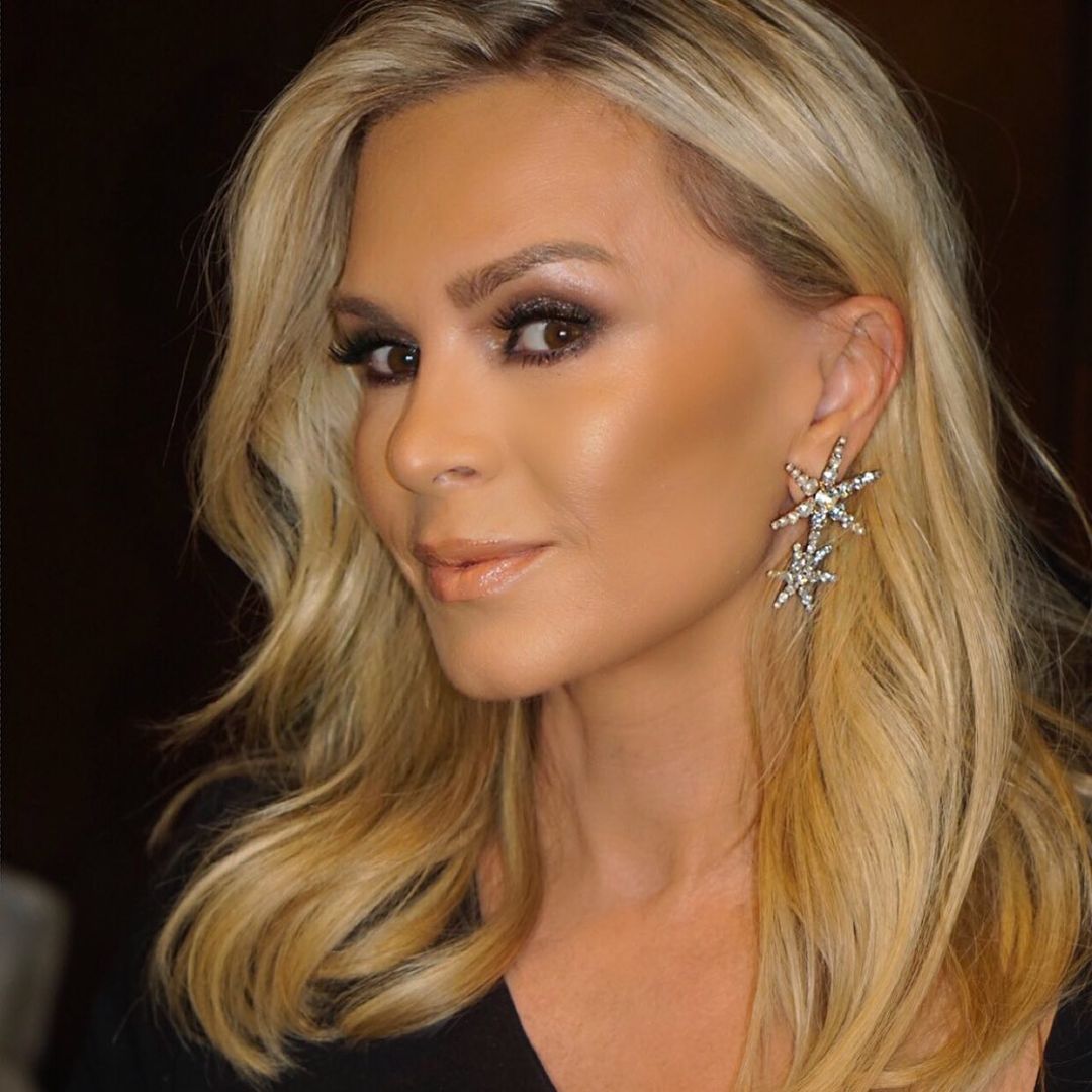 A photo of Tamra Judge with beautifully done make up on a black dress with a smile to match. 