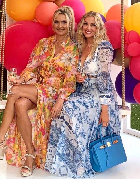 Kary Brittingham and Stephanie Hollman smile in printed sundresses.