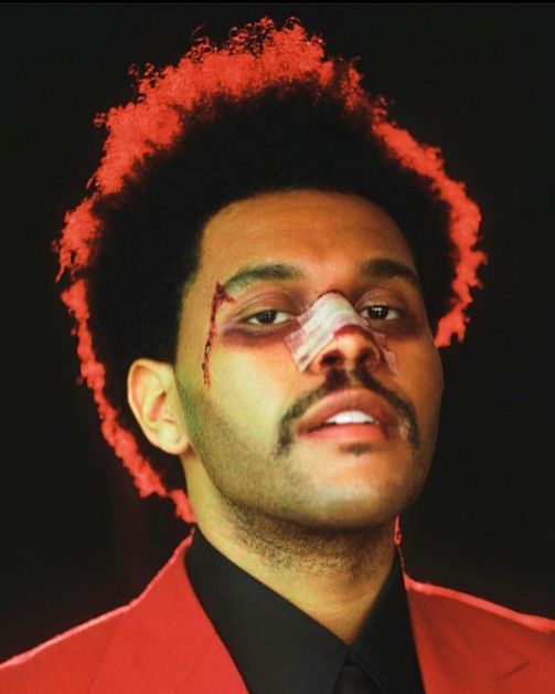 The Weeknd looks into the camera with a bloody bandage over his nose and a cut on the right side of his face.