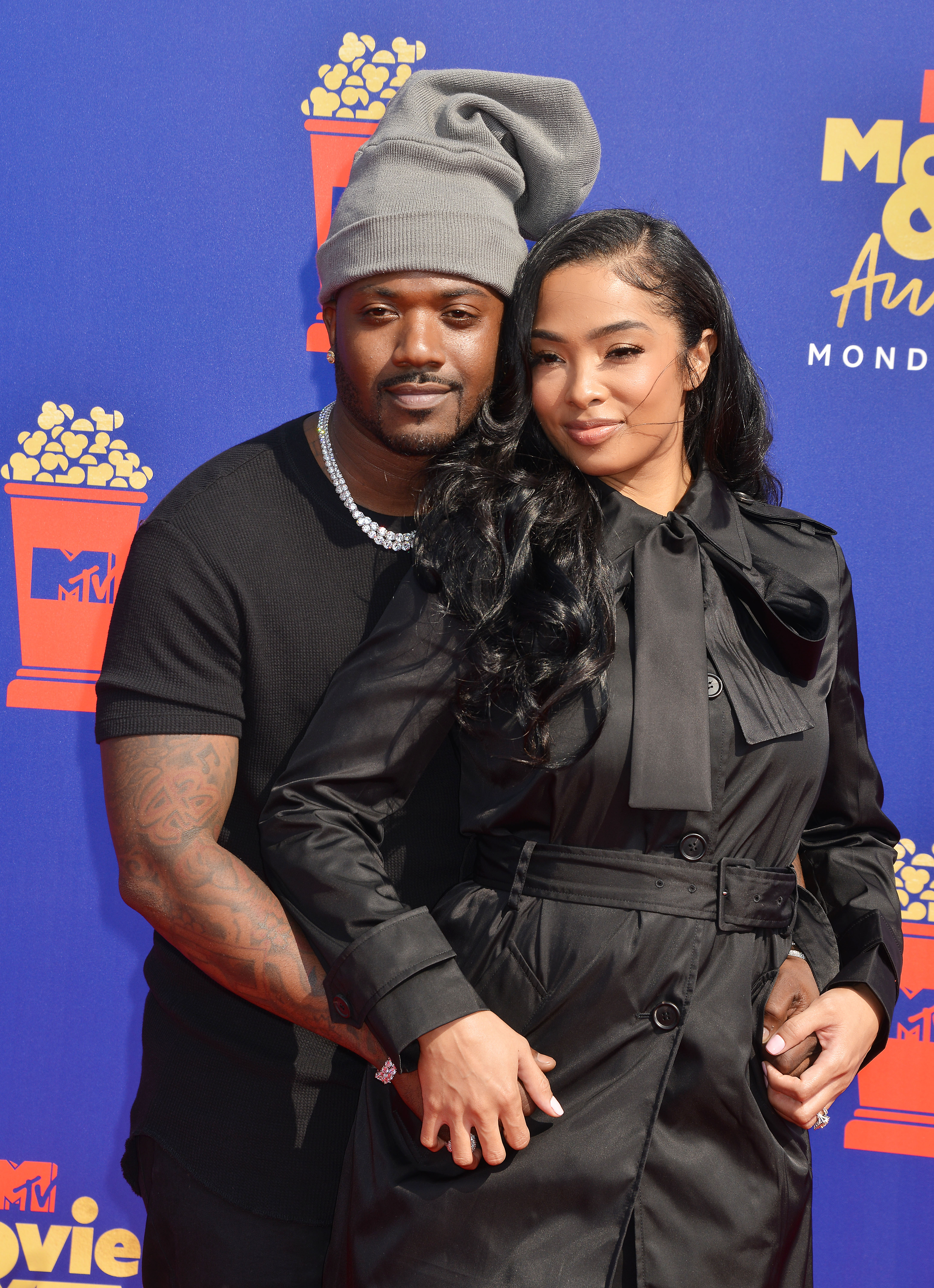 A photo showing Ray J and Princess Love in gorgeous looking black outfits at an event and they’re cozy.