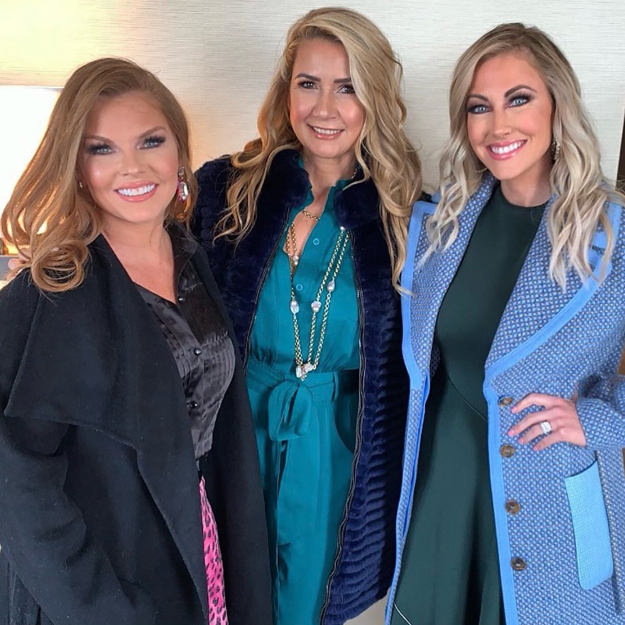 Brandi Redmond, Kary Brittingham, and Stephanie Hollman smile in coats.