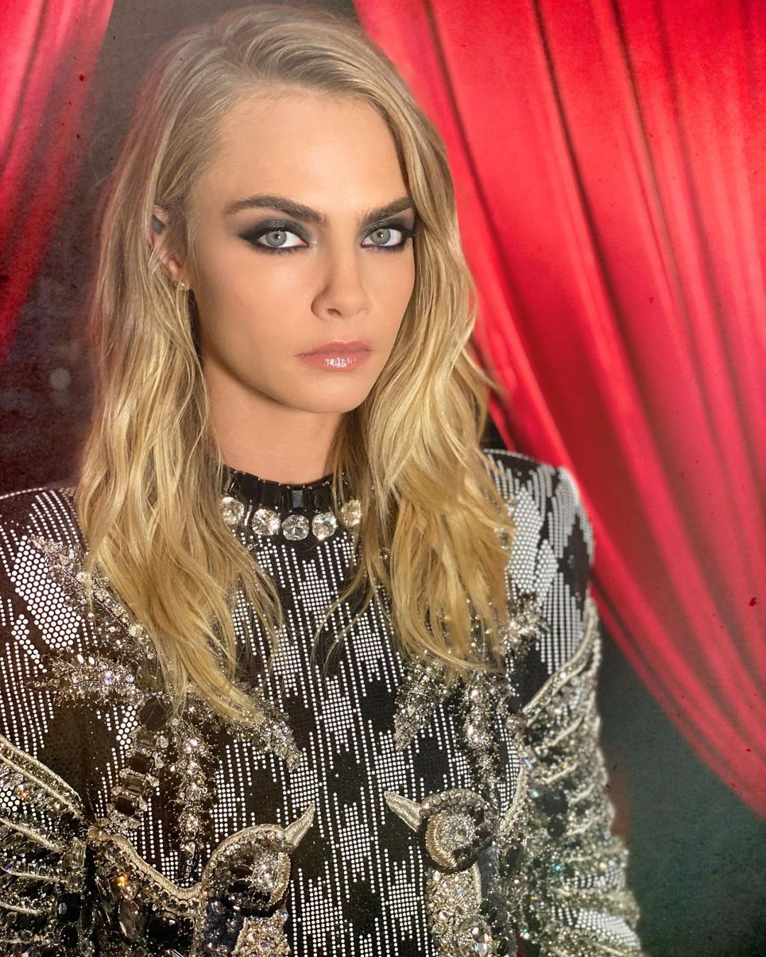 Cara Delevingne looks amazing in this photo showing her in a black and white shimmery outfit and glamorous make-up.