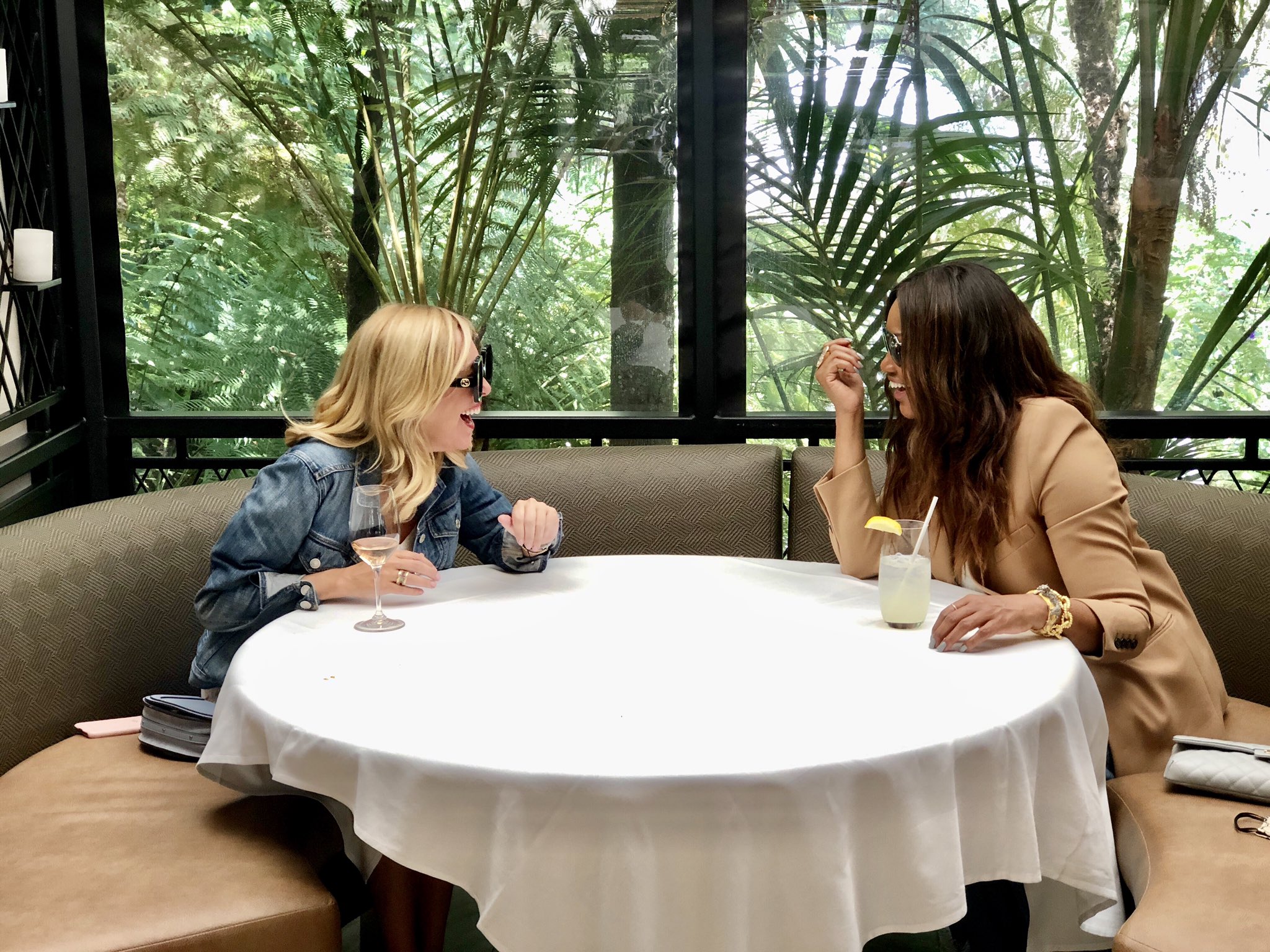 Sutton Stracke and Garcelle Beauvais laugh at a table.