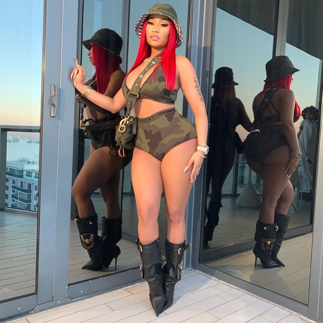 Nicki Minaj looks flawless in this carmouflage two-piece outfit with a matching color bag and hat.