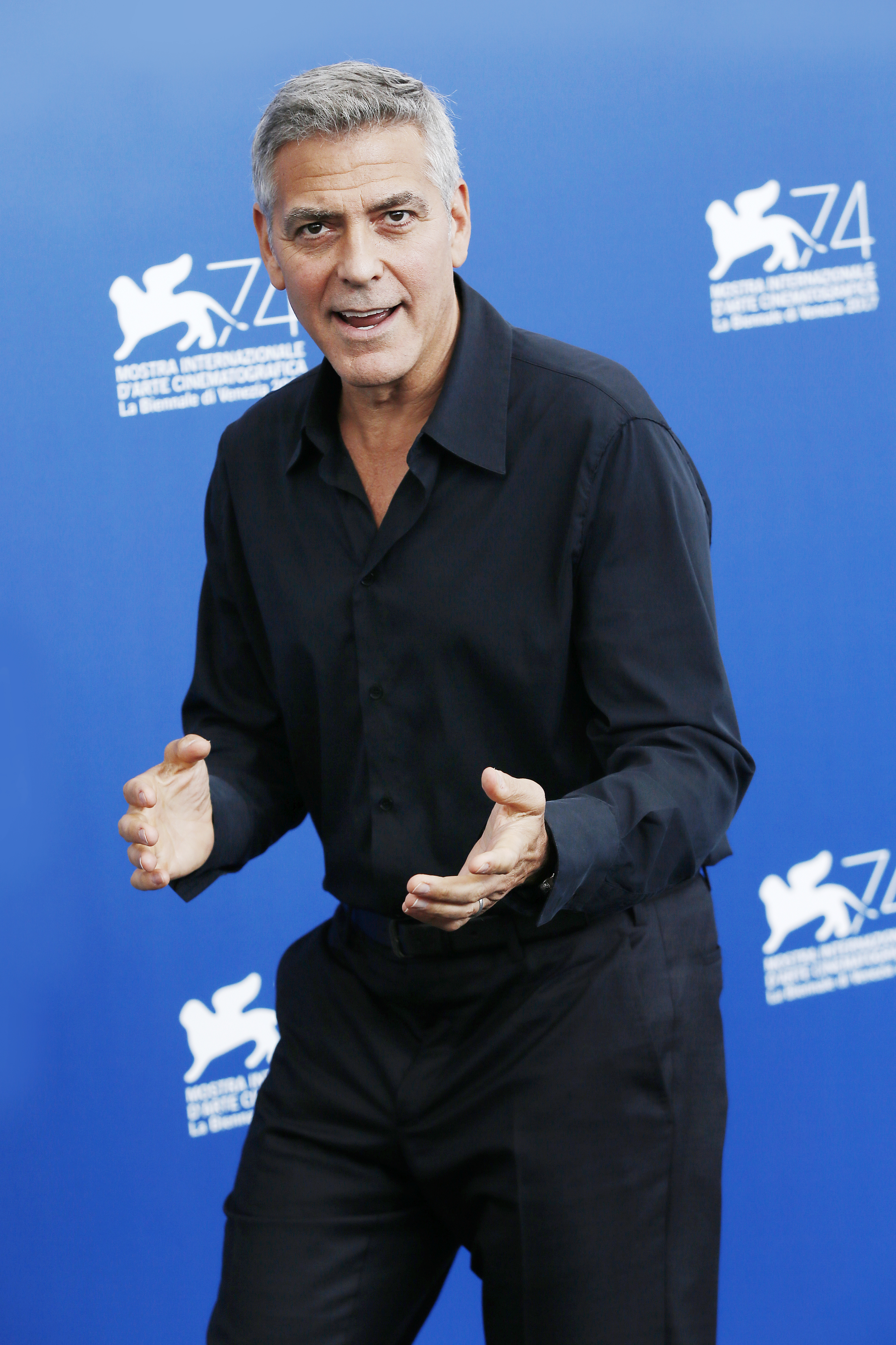 George Clooney is seen in an all black outfit with a dazzling look on his face.