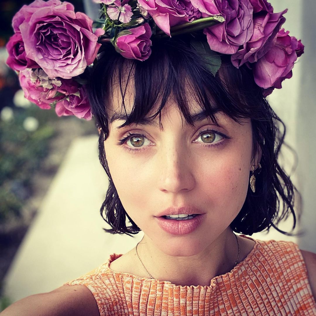 An awesome photo of Ana de Armads with short black hair and a flower-made crown on her head.