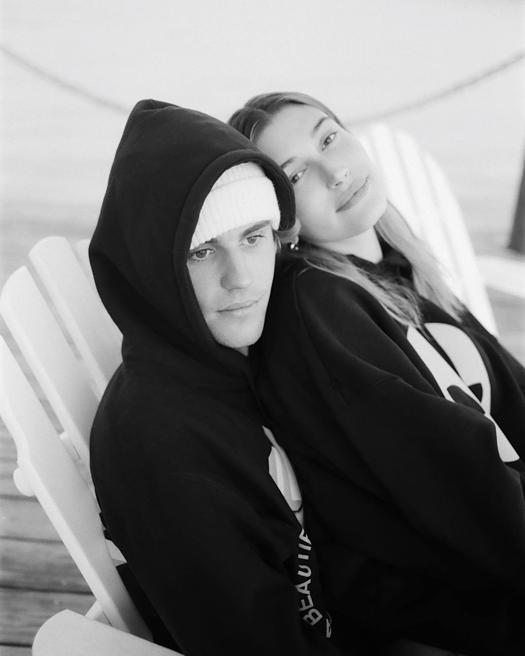 An awesome black and white themed photo showing Hailey Baldwin and Justin Bieber in matching black hoodies. 