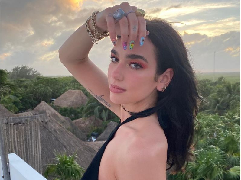 Dua Lipa with gold bracelets on 