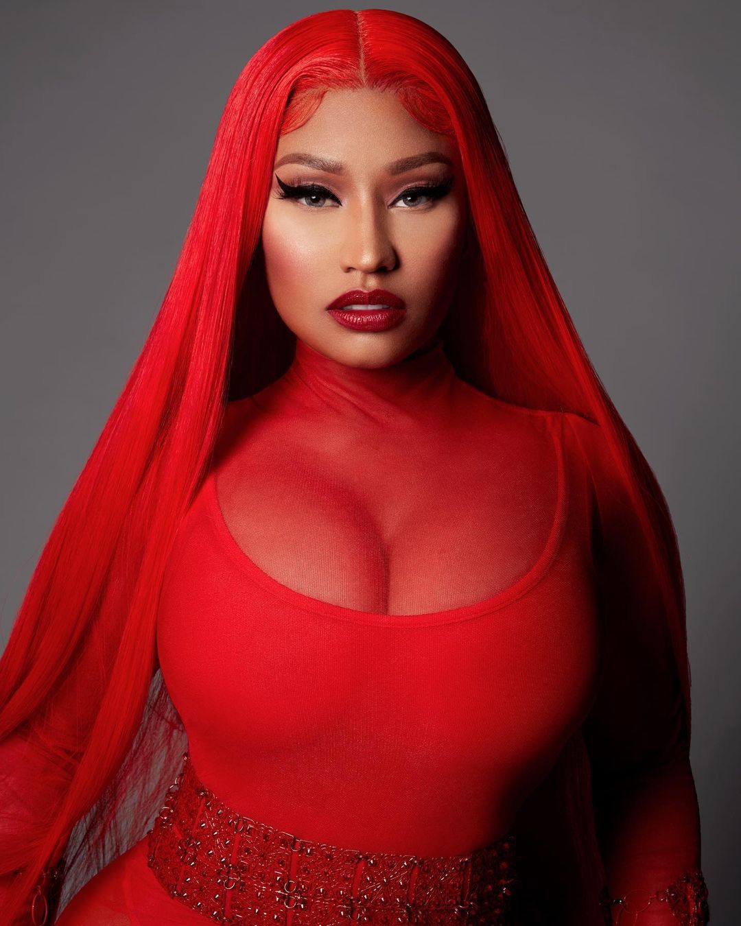 A photo of Niki Minaj sporting a red dress with matching hair color.