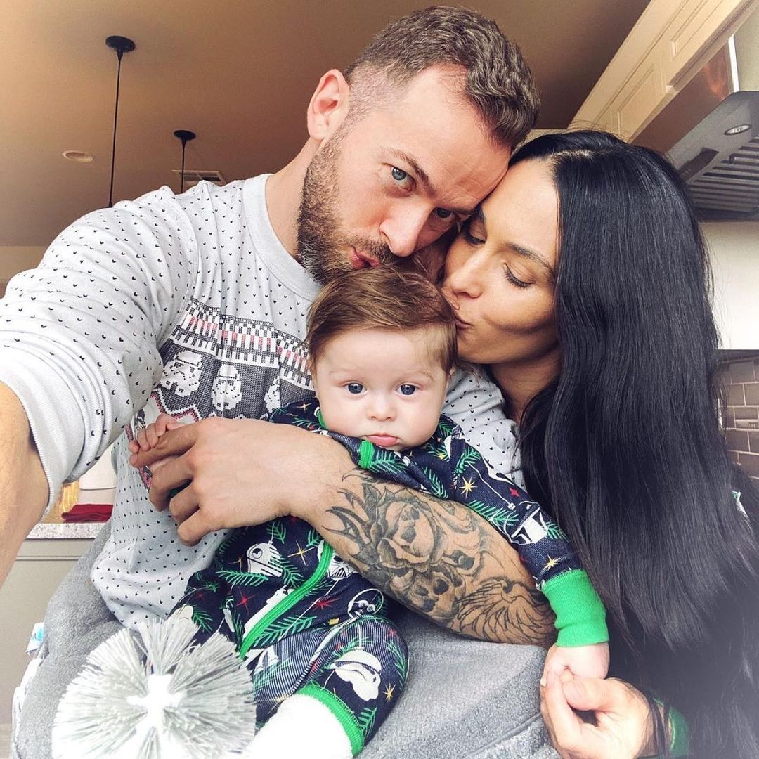 A family photo of Artem Chigvintsev, Nikki Bella and their bundle of joy Matteo.