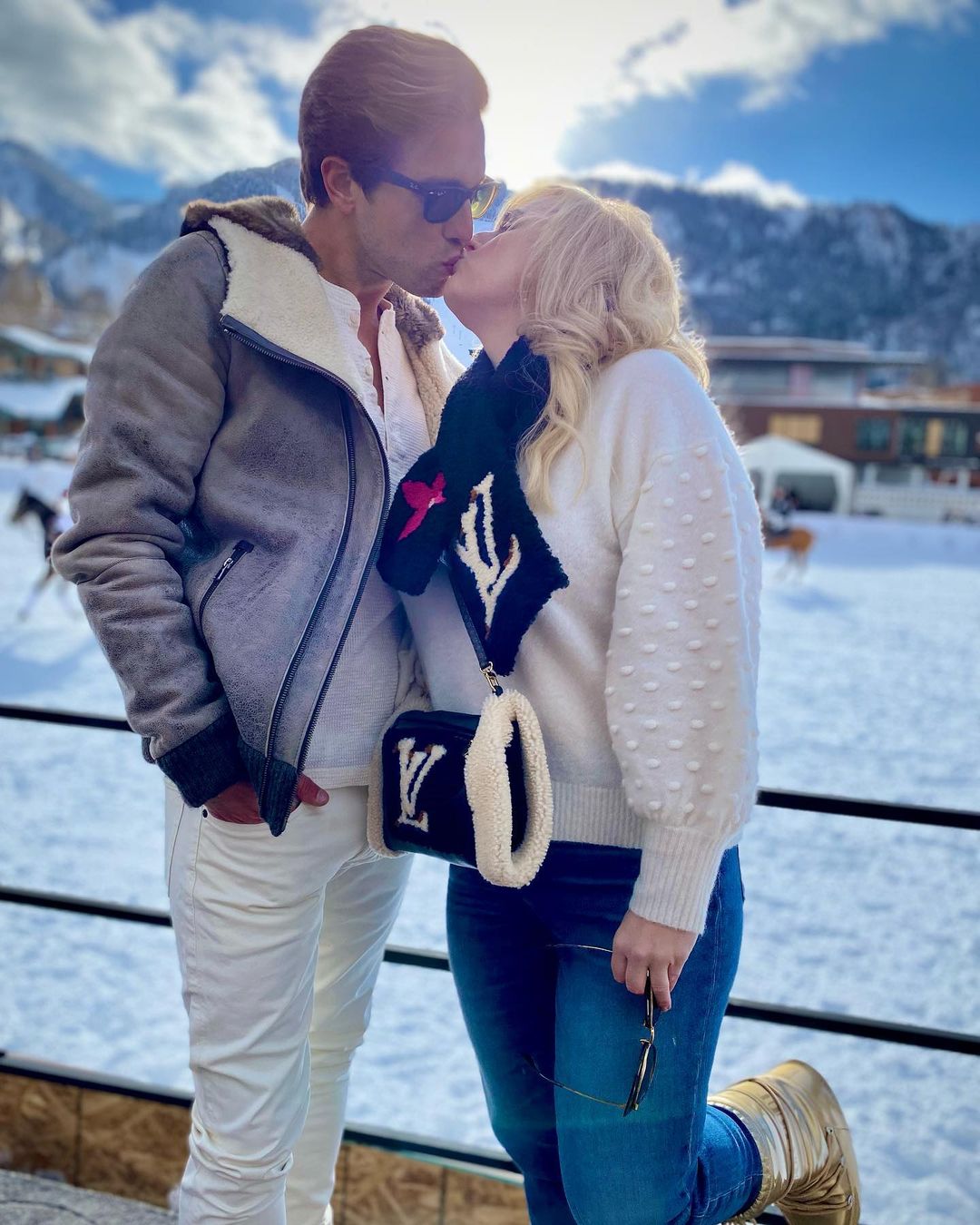  A cute picture of Rebel Wilson and  Jacob Busch kissing in the snow.