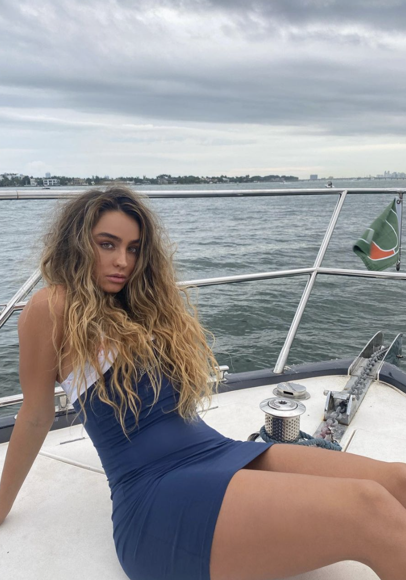 Sommer Ray wearing a skintight mini dress while on a yacht in the ocean.