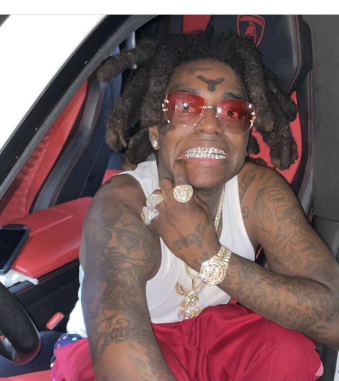 Kodak showing off his iced out grill.