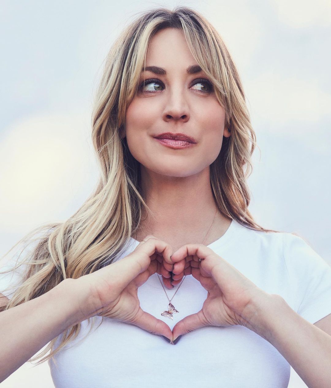 Kaley Cuoco looks amazing in this photo showing her in a white shirt with a butterfly pendant necklace.