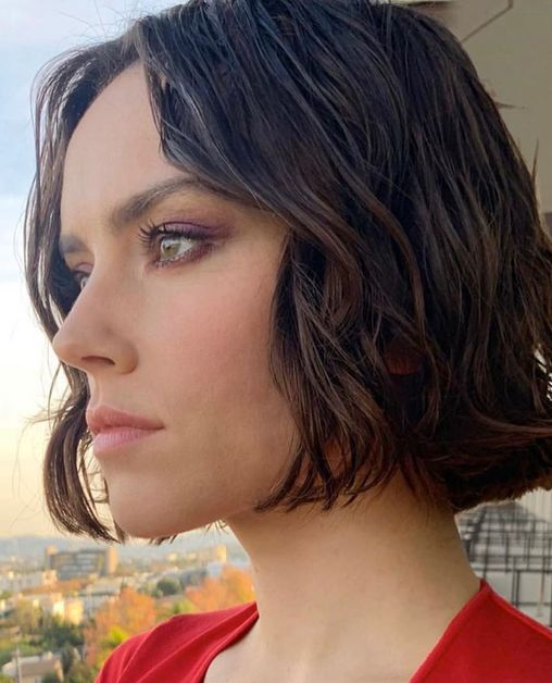 Daisy Ridley looks pensively into a sunset. 