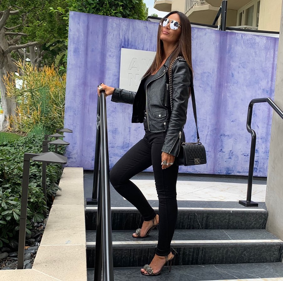 A photo showing Lisa Barlow styled looking flawless in this black leather jacket, inner shirt and denim pant.