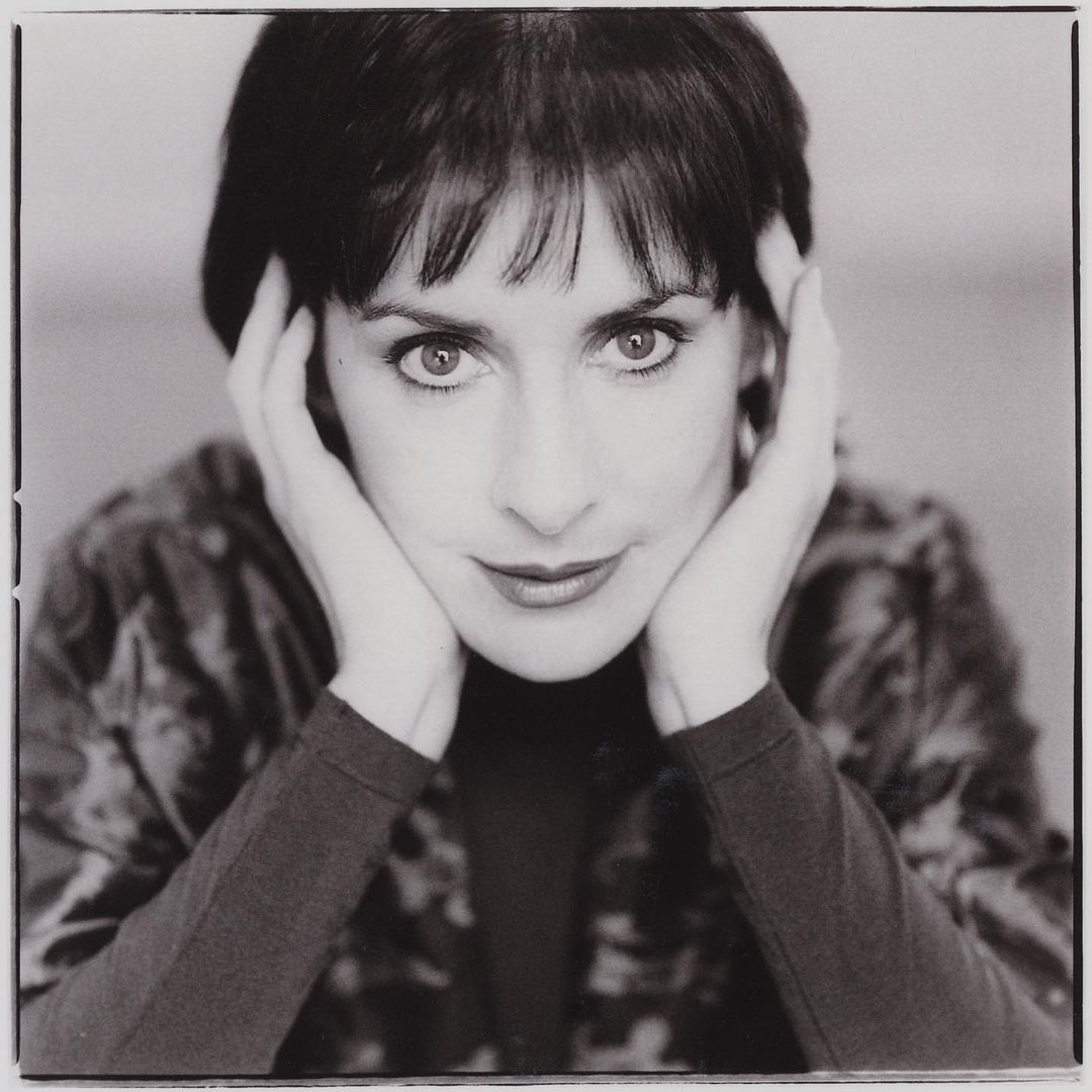 A black and white themed photo of a younger version of Irish singer, Enya.