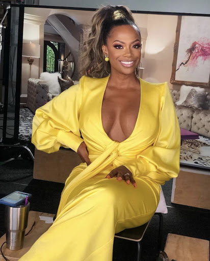 Kandi Burruss wears a low-cut yellow dress.