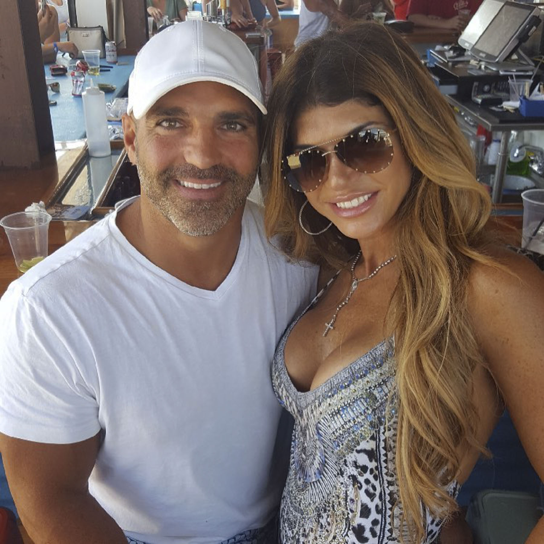 Joe Gorga wears a white shirt and hat with Teresa Giudice.