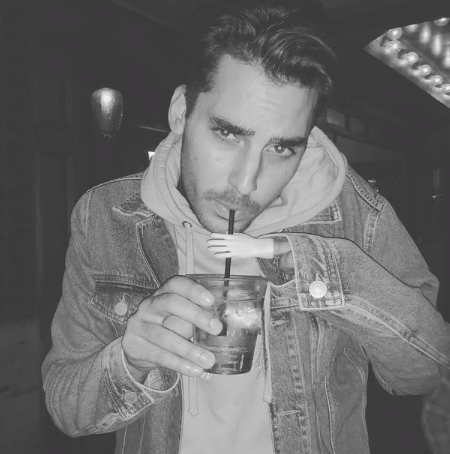 Max Boyens drinks a drink in black and white image.