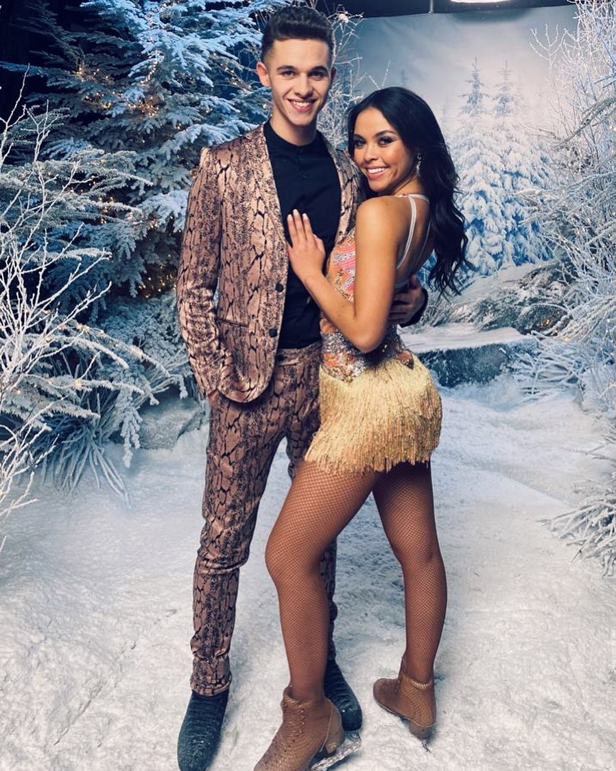 A photo of Joe Warren-Plant and professional skater partner Vanessa Bauer, posing in a snomy background.