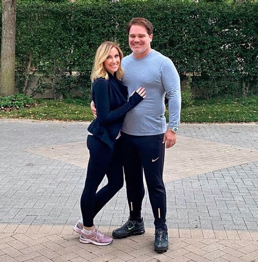 Stephanie Hollman and Travis Hollman wear workout outfits.