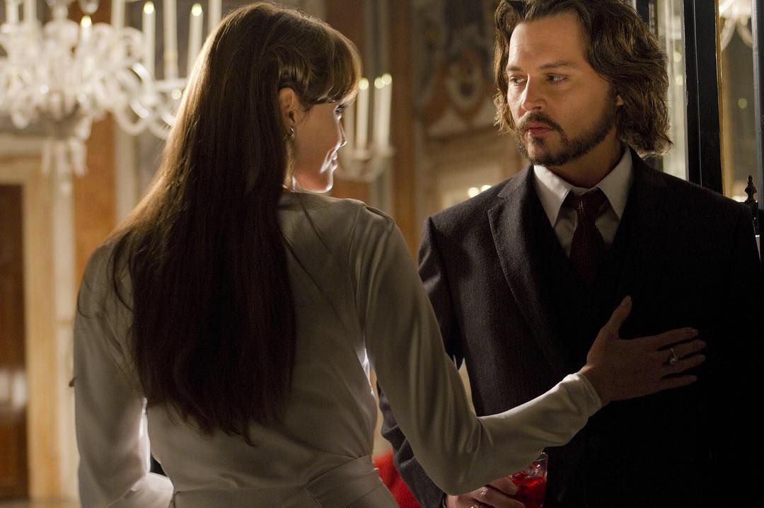 A photo from a scene in 'The Tourist,' showing Jonny Depp and ANgelina Jolie in dance positions, with her hand on his lower chest area.