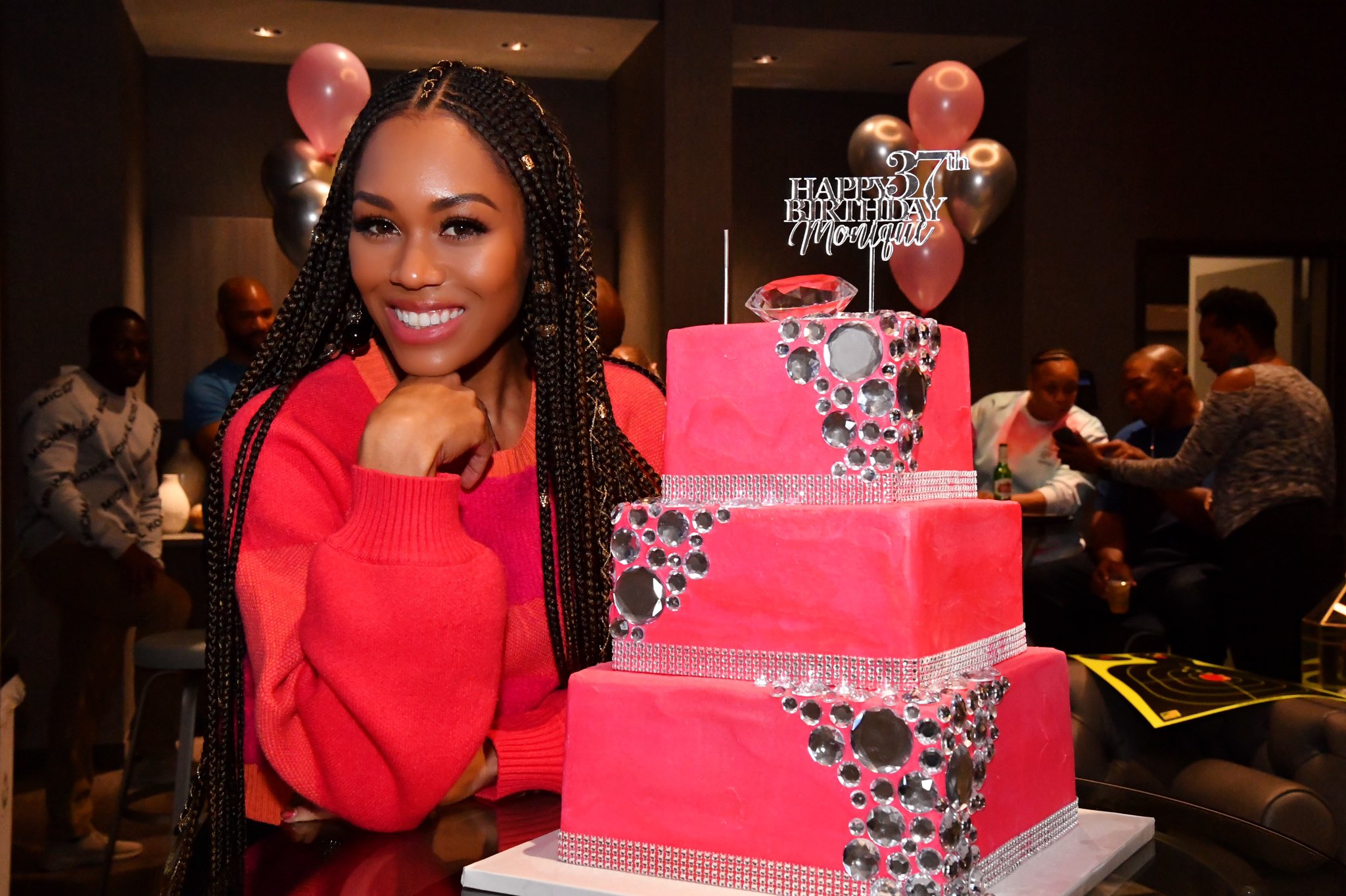 Monique Samuels smiles with a birthday cake.