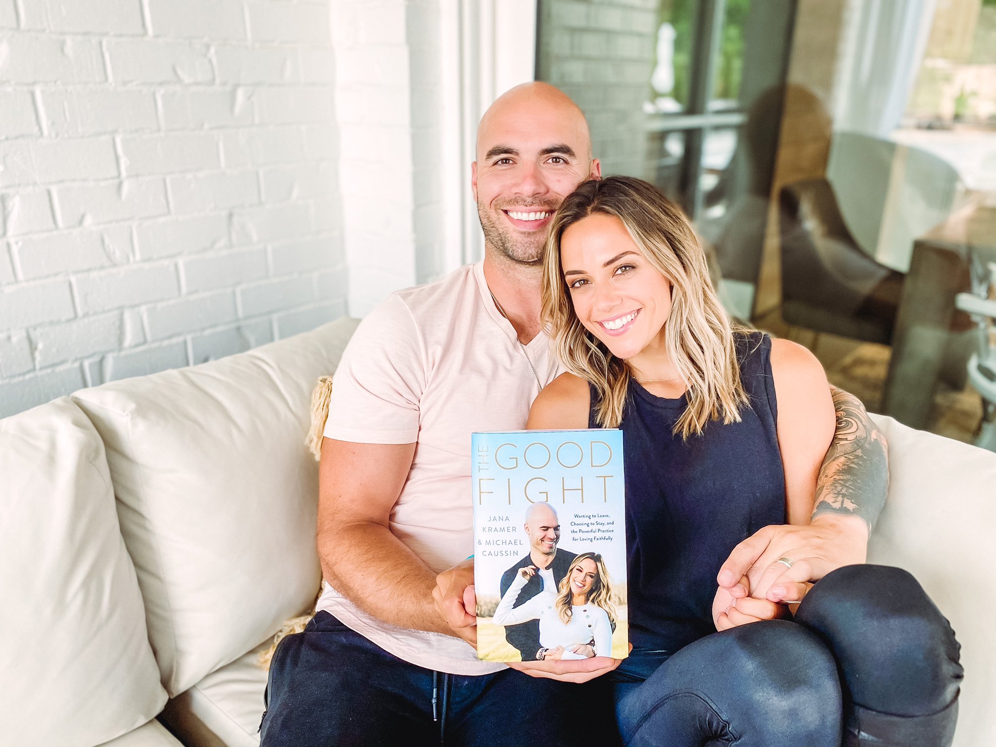 Jana Kramer and Mike Caussin hold a copy of their book, 'The Good Fight.'