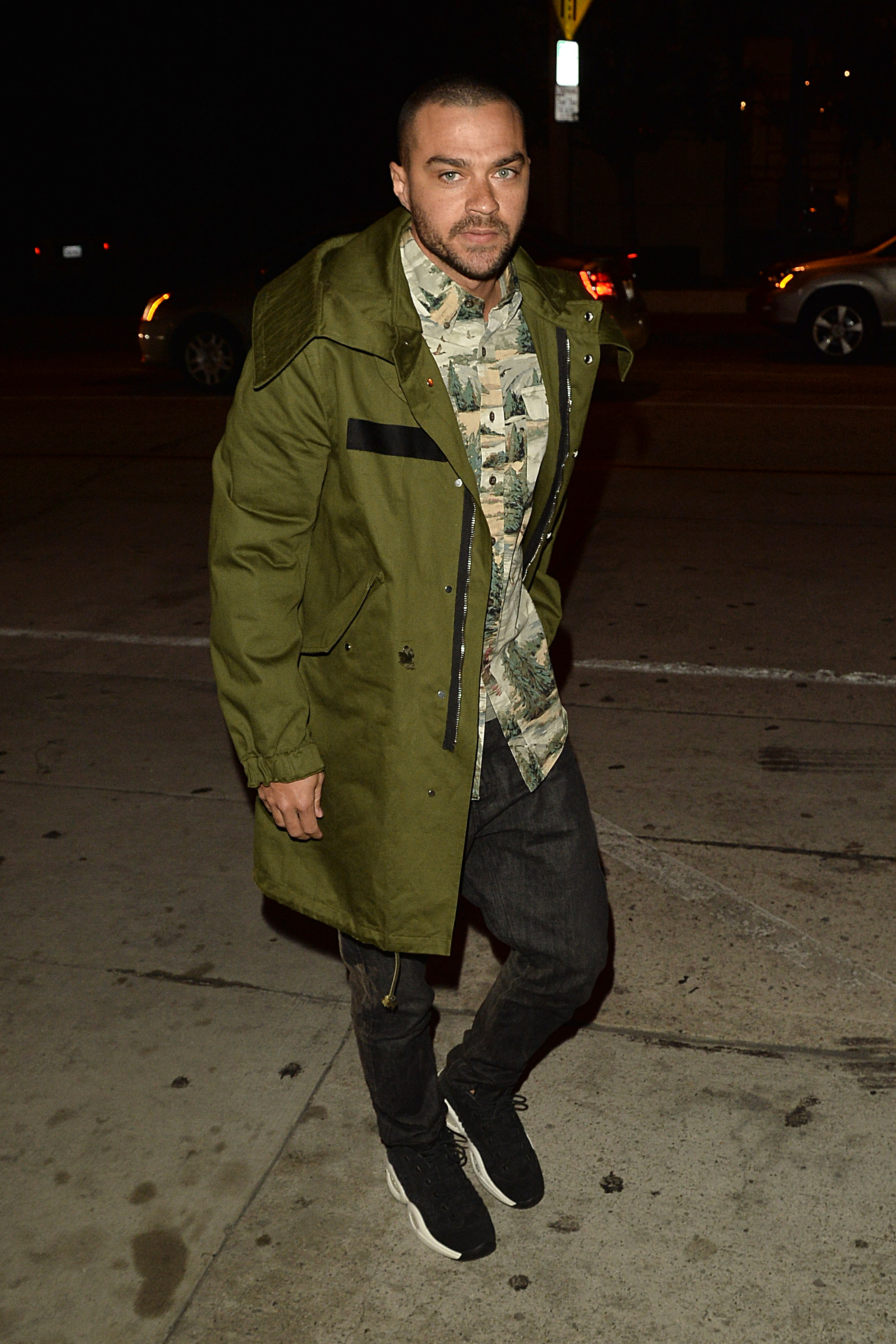 Jesse Williams spotted out and about at night in a green jacket and patterned button-down T-shirt.