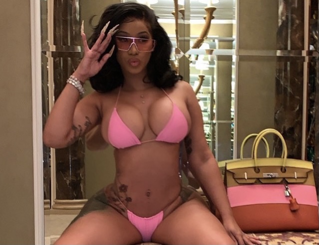 Cardi flaunts a pink bikini with Birkin bags in the background.