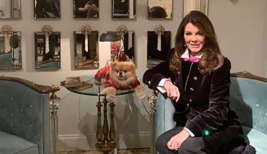 Lisa Vanderpump sits in a blue chair with Siggy.