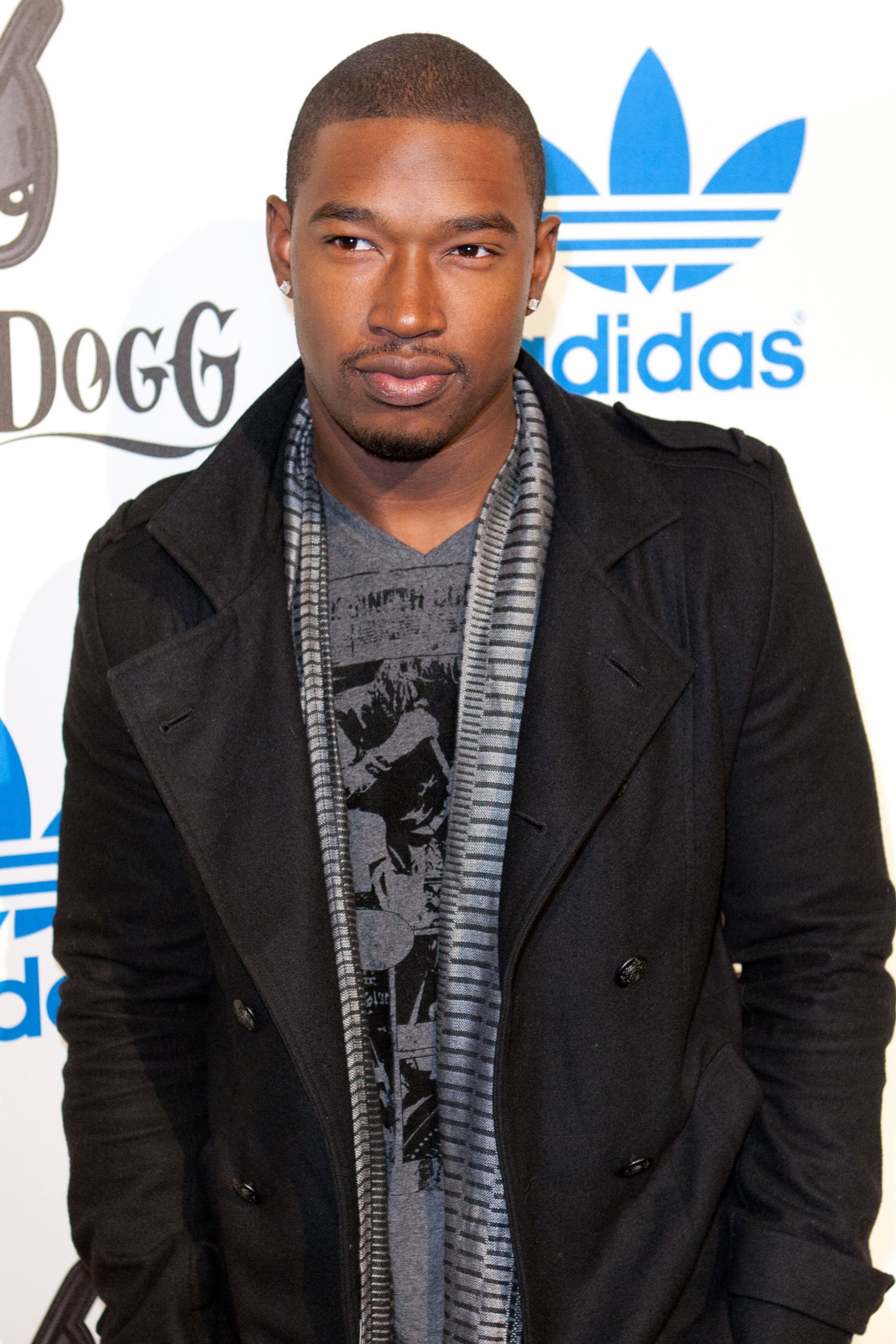 A throwback photo of Kevin McCall sporting a black jacket over a gray shirt and matching color scarf around his neck.