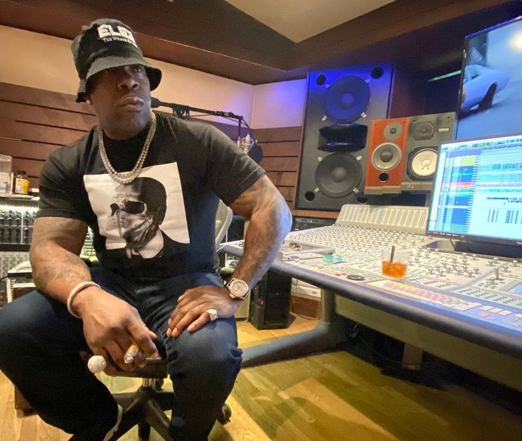 Busta Rhymes sits in the studio, holding a cigar, as he works on his latest music.