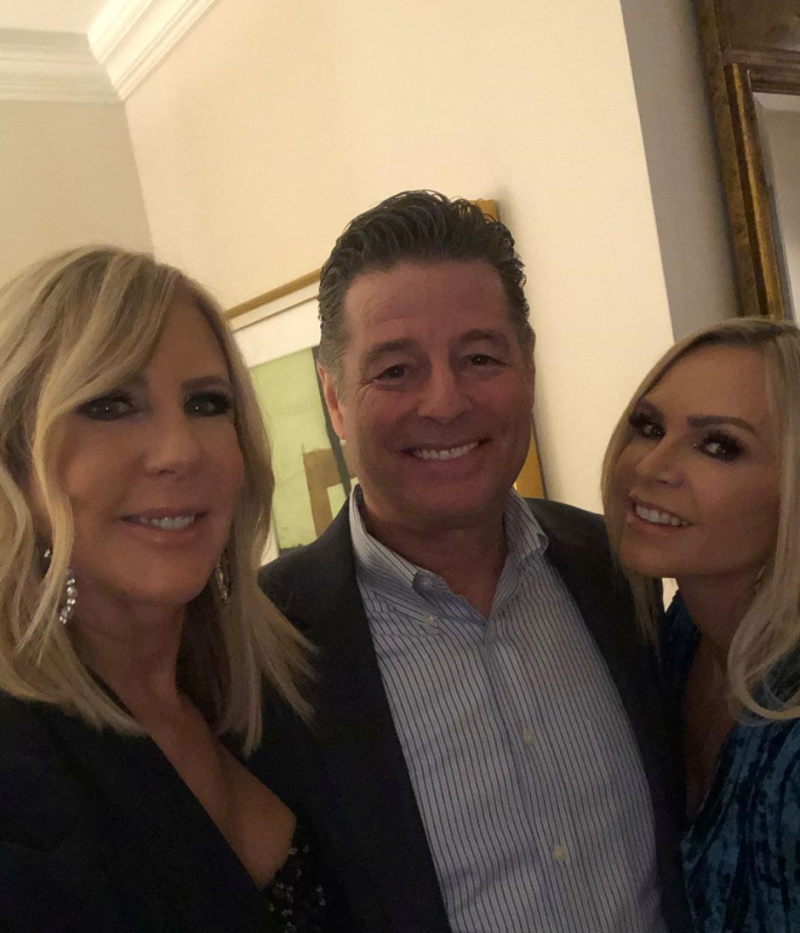 Vicki Gunvalson and Tamra Judge smile with Steve Lodge in a button-down.