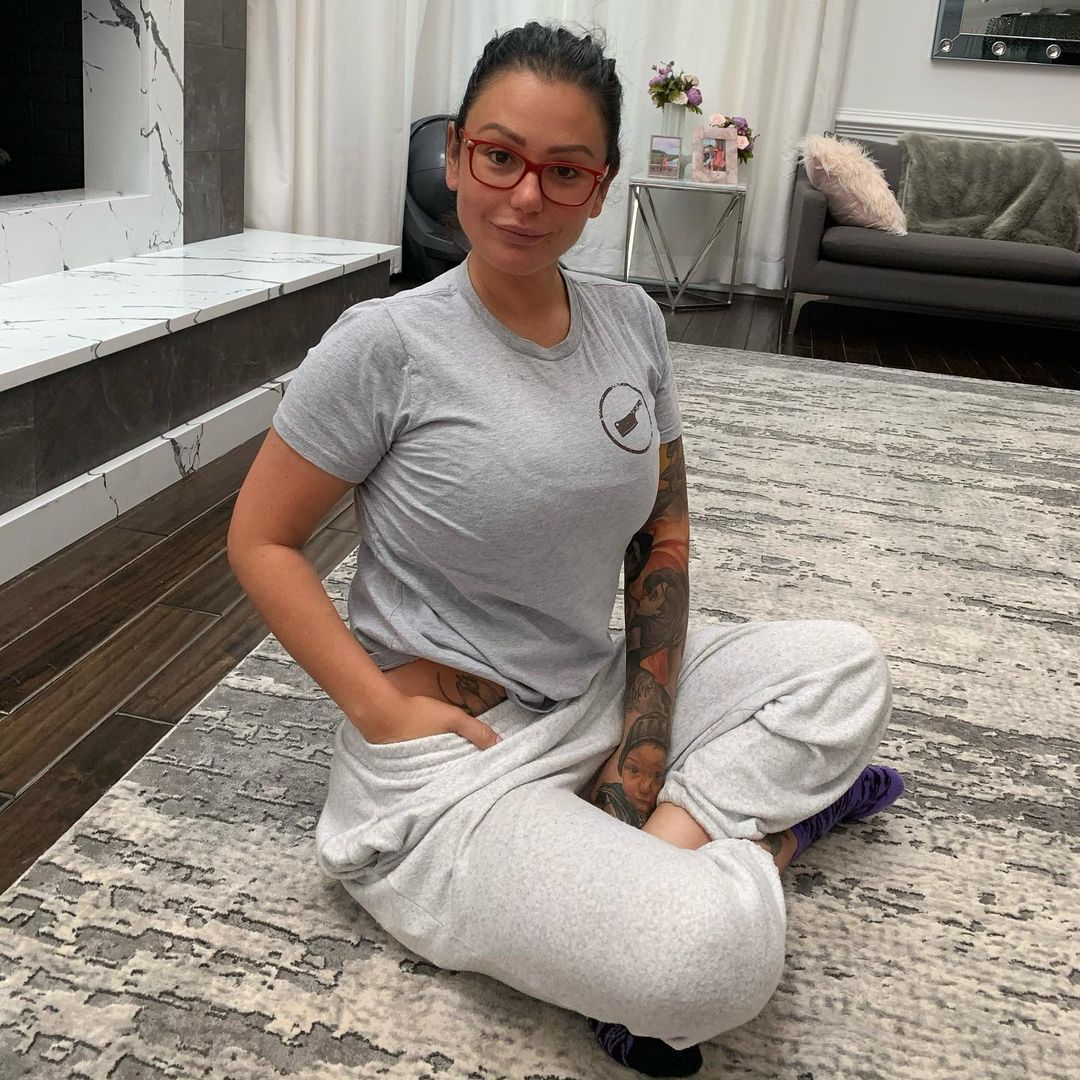 Jenni JWoww Farley looks gorgeous in this meditation pose, and she has on a pair of gray shirt and pant.