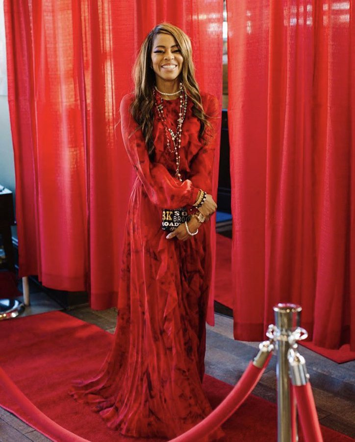 Mary Cosby wears a red gown on the red carpet.