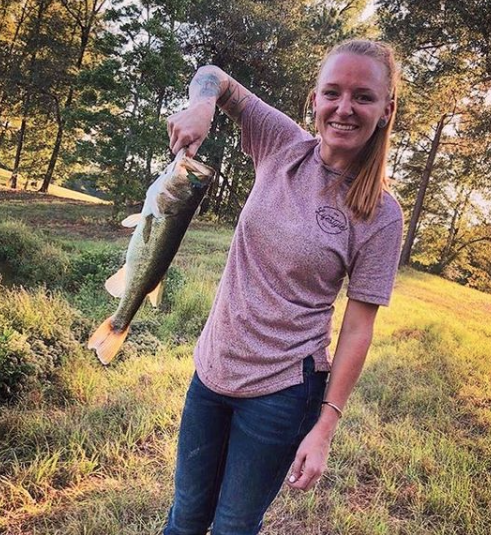 Maci Bookout shows off a fish she caught.