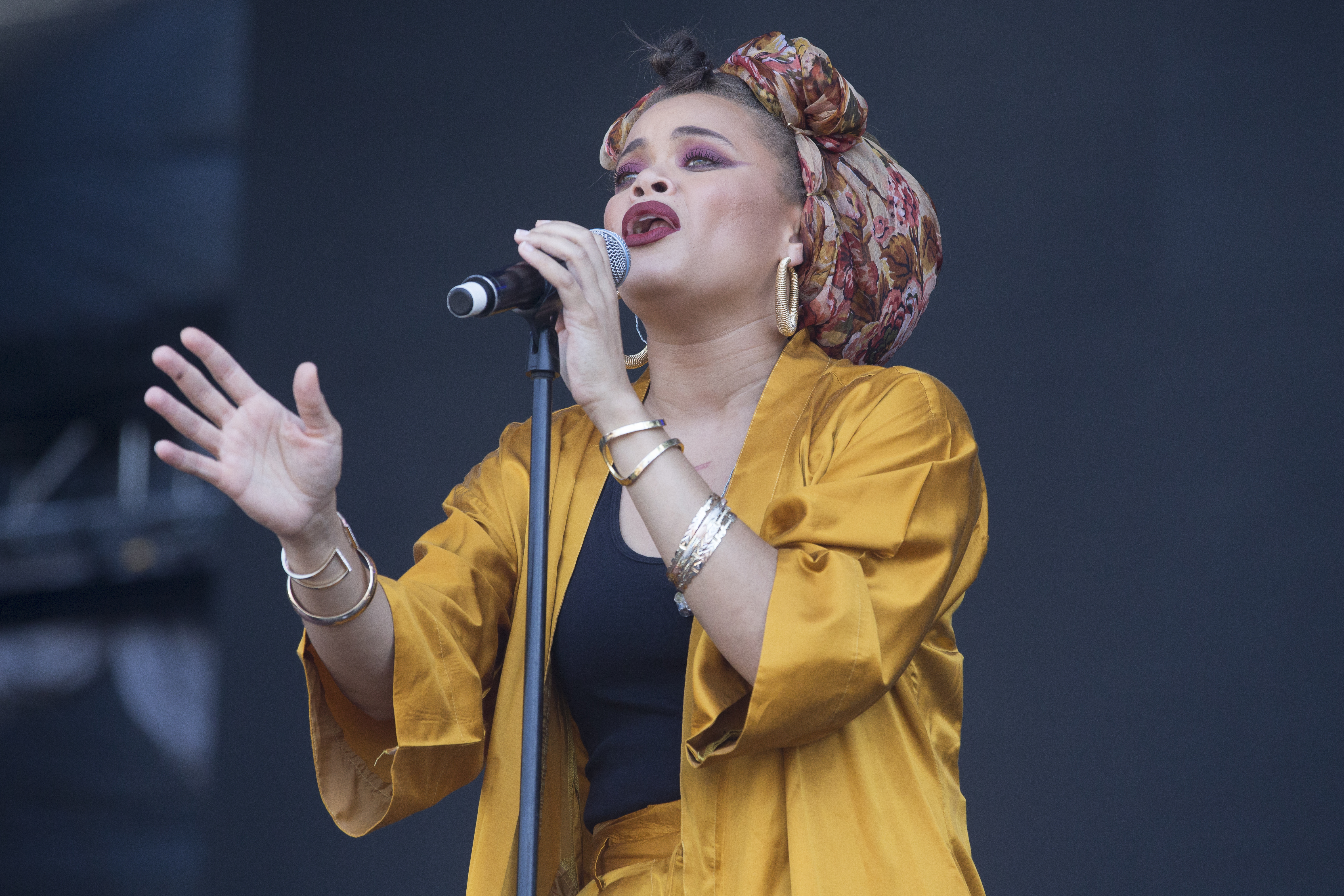 A lovely appearance by Anda Day, showing her performing on a stage in a golden-yellow two-piece outfit and an inner black