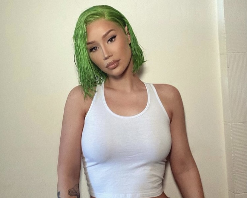 Iggy in a tank top and showing her green hair.