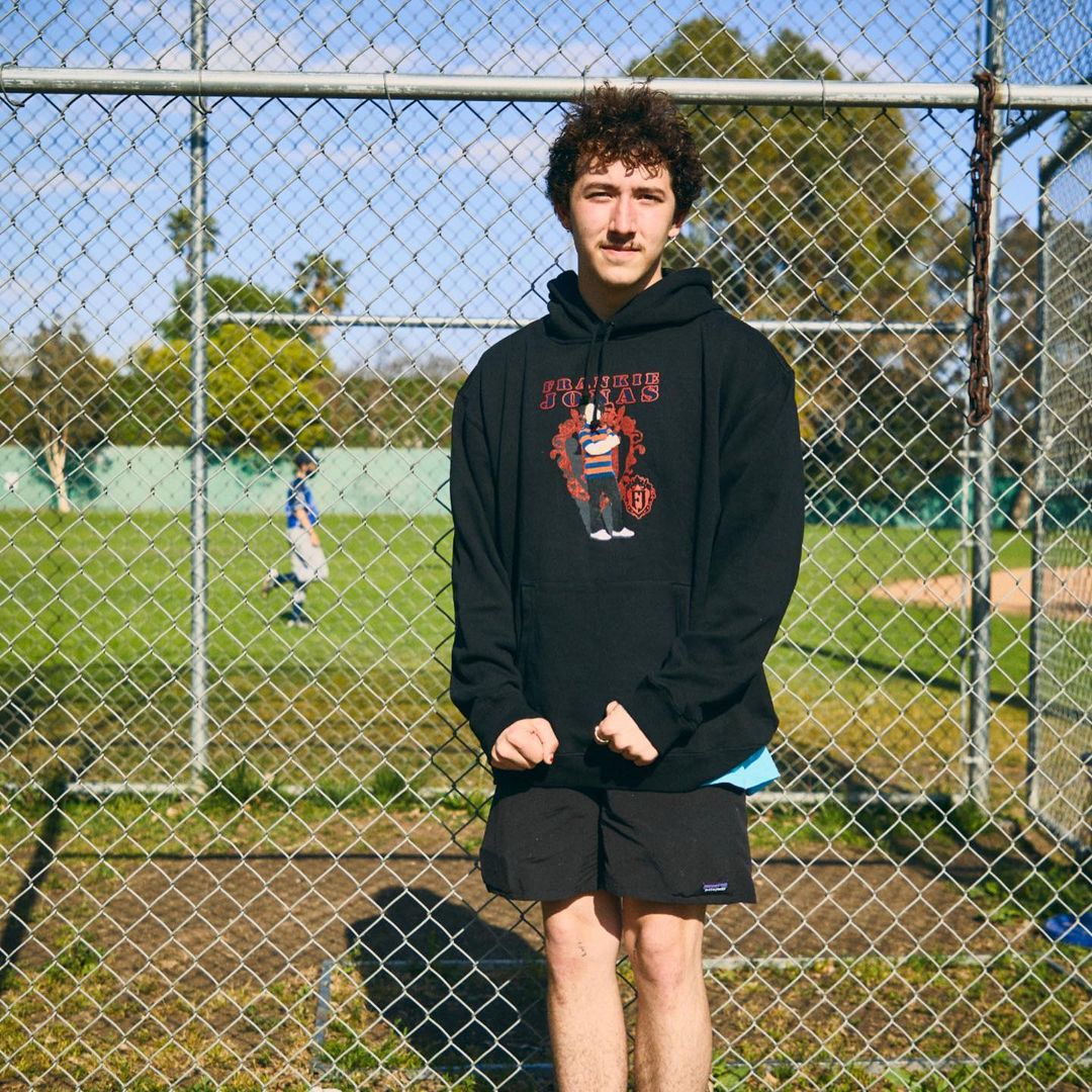 A photo of Franklin Joenas in a black hoodie and matching shorts at a field.