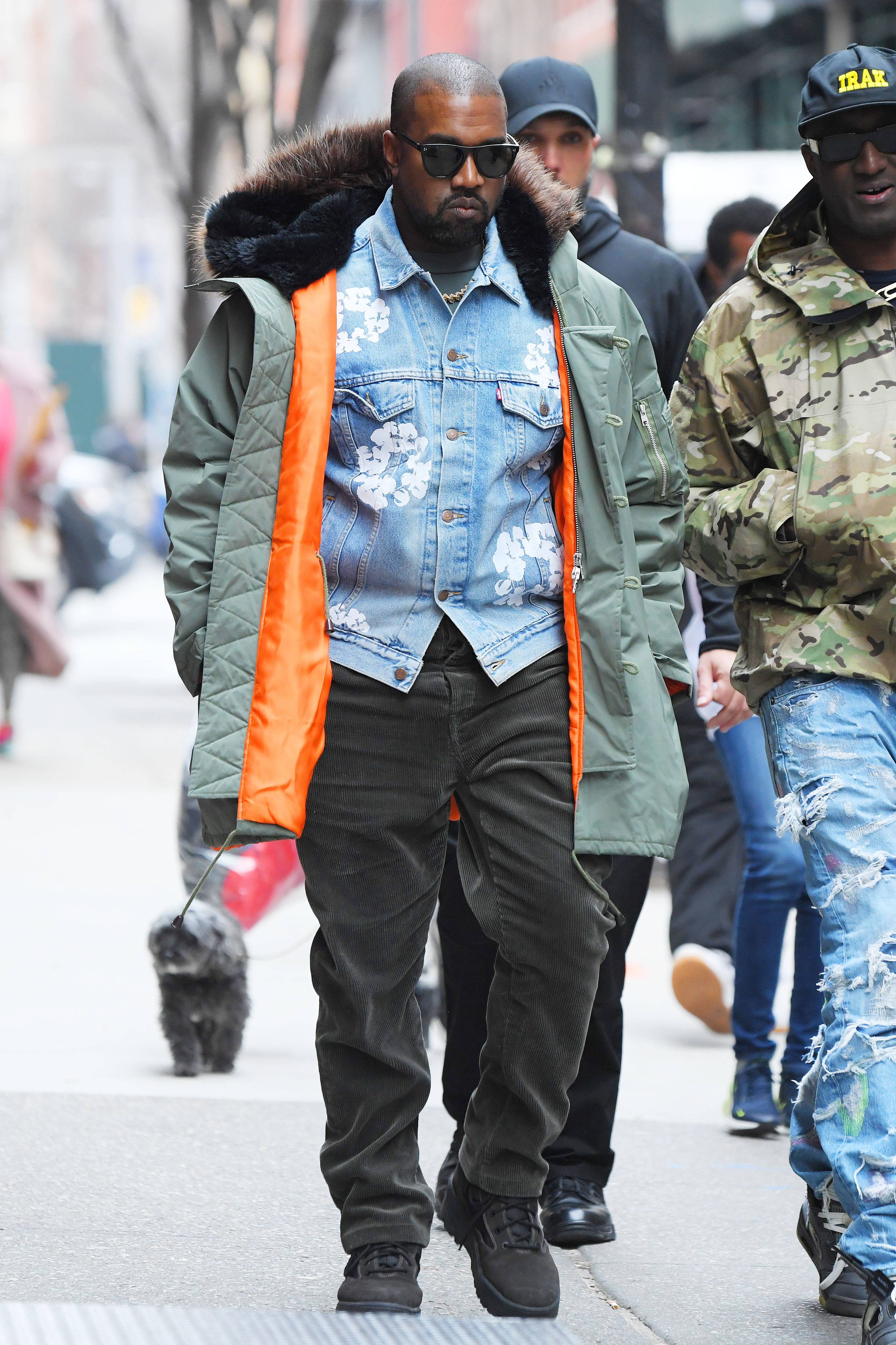 Kanye West spotted on the street in a denim jacket, green coat and pant, with his bodyguards by his side.