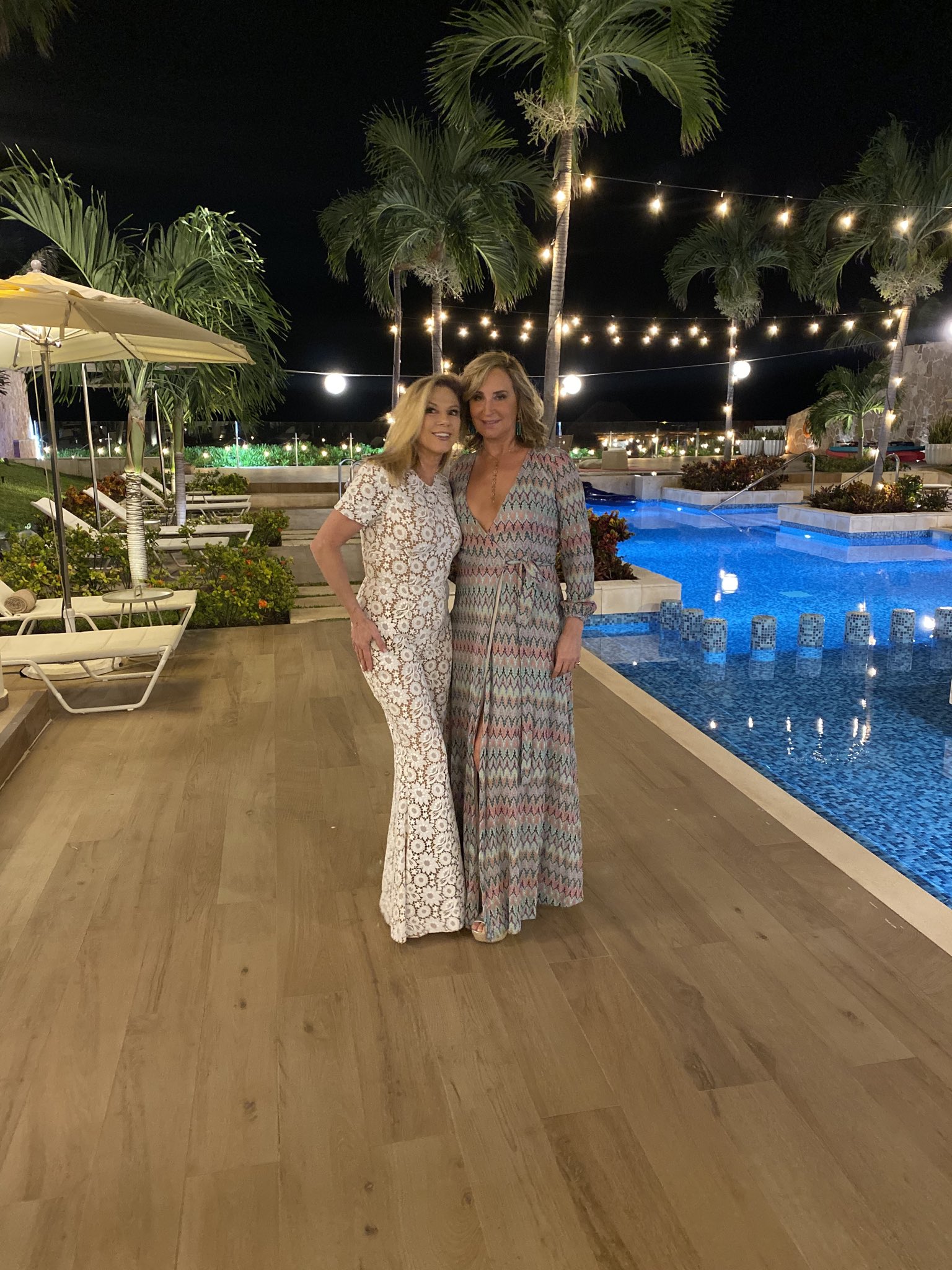 Ramona Singer wears a white jumpsuit with Sonja Morgan in a printed dress.